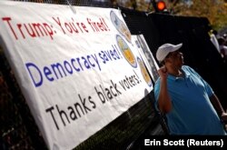 Jerry Nickens, seorang warga asli DC, berpose di depan papan terima kasih kepada pemilih kulit hitam di luar Gereja St. John dekat Gedung Putih di Washington, AS, 8 November 2020. (Foto: REUTERS/Erin Scott)