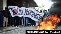 Para pengunjuk rasa membakar ban saat protes deportasi pengungsi Rohingya di Banda Aceh, Aceh, 27 Desember 2023. (Foto: REUTERS/Riska Munawarah)