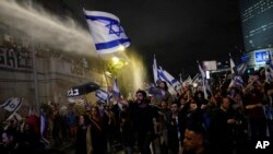 Israeli police use a water cannon to disperse demonstrators blocking the freeway during a protest against plans to overhaul the judicial system in Tel Aviv, Israel, March 25, 2023.