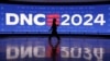 Seorang peserta berjalan melewati layar di United Center, menjelang Konvensi Nasional Demokrat (DNC) di Chicago, Illinois, AS, 19 Agustus 2024. (Kevin Wurm/REUTERS)