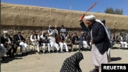 아프가니스탄 탈레반 재판관이 간통 유죄 판결을 받은 여성에게 태형을 집행하고 있다. (자료사진)