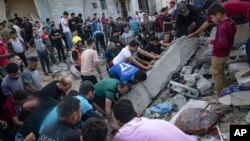 Palestinians look for survivors after Israeli airstrikes in Khan Younis, Gaza Strip, Oct. 16, 2023.