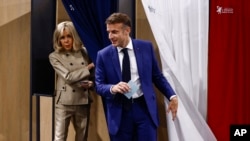 Francuski predsjednik Emmanuel Macron i njegova supruga Brigitte Macron napuštaju glasačku kabinu prilikom glasanja u Le Touquet-Paris-Plage, sjeverna Francuska, 30. juna 2024.