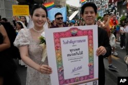 FILE - Peserta Parade Kebanggaan (Pride) memegang poster untuk merayakan kesetaraan dalam pernikahan di Bangkok, Thailand, 1 Juni 2024. (AP/Sakchai Lalit, File)
