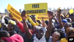 FILE - Supporters of Zimbabwe's main opposition leader Nelson Chamisa hold placards upon his arrival for a a rally on the outskirts of Harare on July 17, 2023.