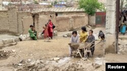 Children are seen gathered in a flood-damaged courtyard following heavy rains, in Kar Kar village, Baghlan province, Afghanistan, May 11, 2024.
