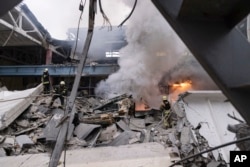 Firefighters work to extinguish a fire after a Russian attack in Kharkiv, Ukraine, Dec. 29, 2023.