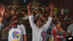 Fans of Indian superstar Rajinikanth, cheer at a cinema hall as they celebrate the screening of his latest film, 'Jailer,' in Mumbai, India, Aug. 10, 2023. 