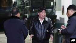 In this photo provided by the North Korean government, North Korean leader Kim Jong Un, center, inspects as he tours munitions factories in North Korea on Jan. 8-9, 2024. 