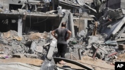 A Palestinian man looks at the remnants of a building destroyed by Israeli bombardment of the Gaza Strip, at the Maghazi refugee camp, in Deir Al-Balah, Oct. 25, 2023.