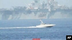 A Revolutionary Guard speedboat moves near USS Bataan at the Strait of Hormuz.