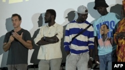 Matteo Garrone (G), réalisateur italien du film "Io Capitano", s'exprime après la projection du film au CDEPS (centre pour le développement de l'entreprenariat et la professionnalisation des jeunes) à Rufisque le 17 avril 2024. (Photo by SEYLLOU / AFP)