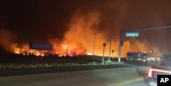 This photo provided by County of Maui shows fire and smoke filling the sky from wildfires on the intersection at Hokiokio Place and Lahaina Bypass in Maui, Hawaii on Tuesday, Aug. 8, 2023. (Zeke Kalua/County of Maui via AP)