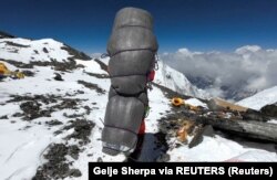 Ngima Tashi Sherpa berjalan sambil menggendong seorang pendaki Malaysia saat menyelamatkannya dari zona kematian di atas kamp empat di Everest, Nepal, 18 Mei 2023. (Foto: Gelje Sherpa via REUTERS)