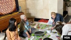 Beberapa pengunjung mencoba membatik di acara Passport DC di Washington DC, Sabtu, 6 Mei 2023. (Foto: V0A)