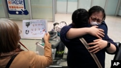 资料照：北京首都国际机场一名女子等到了乘坐国际航班抵达北京的亲人。（2023年3月14日）