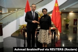 Menteri Luar Negeri Wang Yi dan Menteri Luar Negeri Retno Marsudi berjabat tangan saat pertemuan mereka di Jakarta, 18 April 2024. (Foto: Achmad Ibrahim/Pool via REUTERS)