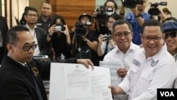 Ketua Tim Kuasa Hukum Paslon Presiden dan Wakil Presiden 01, Ari Yusuf Amir (kanan) memberikan berkas PHPU Pemilu Presiden 2024 ke perwakilan MK di Jakarta, Kamis (21/3). (VOA/IndraYoga)