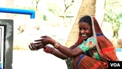 پانی پراجیکٹ کے ایک سولر واٹر پمپ سے پانی حاصل کرنے والی تھر کی ایک مسکراتی خاتون