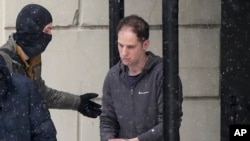 FILE - Wall Street Journal reporter Evan Gershkovich is escorted from court after a hearing in Moscow, Jan. 26, 2024. Arrests of Americans have become increasingly common as relations between Moscow and Washington sink to Cold War lows.