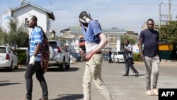 Des blessés marchent pour trouver de l'ombre après avoir été soignés à l'hôpital Mama Lucy Kibaki pour des blessures subies à la suite d'une explosion de gaz dans le quartier d'Embakasi à Nairobi, le 2 février 2024. (Photo par Tony KARUMBA / AFP)