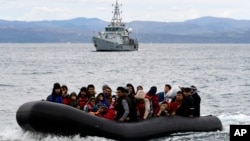 FILE - Migrants arrive accompanied by a Frontex vessel at Skala Sikaminias, on the Greek island of Lesbos, after crossing from Turkey, Feb. 28, 2020. Greece in May 2023 has ordered a probe of what some are calling an illegal roundup and pushback of migrants out to sea.