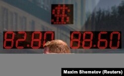 Seorang pria berjalan melewati papan yang menunjukkan nilai tukar dolar AS dan Euro terhadap rubel Rusia di Moskow, Rusia, 19 Juni 2024. (Foto: REUTERS/Maxim Shemetov)