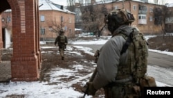 Ukrainian servicemen walk along a street in the front line city of Bakhmut, in Ukraine's Donetsk region, Feb. 9, 2023.