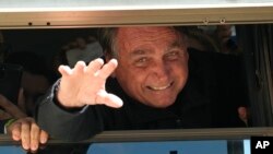 Mantan Presiden Brazil Jair Bolsonaro melambaikan tangan kepada para pendukungnya di markas Partai Liberal di Brasilia, Brasil, Kamis, 30 Maret 2023. (AP/Eraldo Peres)