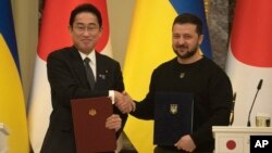 Japanese Prime Minister Fumio Kishida, left, and Ukrainian President Volodymyr Zelenskyy, greet each other after the signing of joint documents in Kyiv, Ukraine, March 21, 2023.