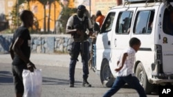A police officer inspects a public transportation vehicle at a checkpoint in Port-au-Prince, Haiti, Jan. 26, 2024.
