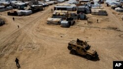 FILE - Kurdish forces patrol al-Hol camp, which houses families of members of the Islamic State group in Hasakeh province, Syria, on April 19, 2023. 