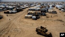 FILE - Kurdish forces patrol al-Hol camp, which houses families of members of the Islamic State group in Hasakeh province, Syria, April 19, 2023.