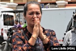 អ្នកស្រី ថាច់ សុខបូរ៉ានី ភរិយារបស់លោក ថាច់ សេដ្ឋា អនុប្រធានគណបក្សភ្លើងទៀន លើកដៃសំពះអ្នកមកគាំទ្រស្វាមី នៅខាងមុខសាលាដំបូងរាជធានីភ្នំពេញ កាលពីថ្ងៃ១០ ខែឧសភា ឆ្នាំ២០២៣។ (លាស់ លីបលីប/ វីអូអេ)