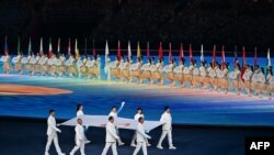 Para mantan atlet membawa bendera Dewan Olimpiade Asia saat upacara pembukaan Asian Games 2022 di Provinsi Zhejiang timur China pada 23 September 2023. (Foto; AFP)