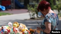 ผู้หญิงคนหนึ่งยืนร้องไห้ที่หน้าอนุสรณ์ชั่วคราวสำหรับเหยื่อการยิงถล่มที่ทางการรัสเซียอ้างว่าเป็นฝีมือของยูเครน ที่เมืองเซวาสโตโพล แคว้นไครเมีย เมื่อ 24 มิ.ย. 2567
