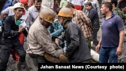 معدنچیان در حال خروج پیکر یکی از همکاران کشته شده خود هستند.
