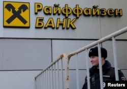 Seorang polisi Rusia berdiri di depan cabang Bank Raiffeisen di Moskow, Rusia, 27 Februari 2016. (Foto: REUTERS/Maxim Shemetov)