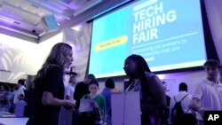 FILE - Visitors attend the Venture Miami Tech Hiring Fair at the Miami-Dade College, Wolfson campus, April 26, 2023, in Miami.