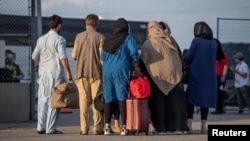 FILE - Afghan refugees who supported Canada's mission in Afghanistan prepare to board buses after arriving in Canada, at Toronto Pearson International Airport, Aug. 24, 2021. (Canadian Armed Forces Photo/Handout via Reuters)