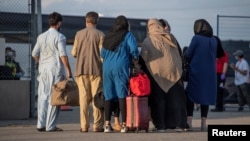Afghan refugees who supported Canada's mission in Afghanistan prepare to board buses after arriving in Canada, at Toronto Pearson International Airport, Aug. 24, 2021. (Canadian Armed Forces via Reuters)