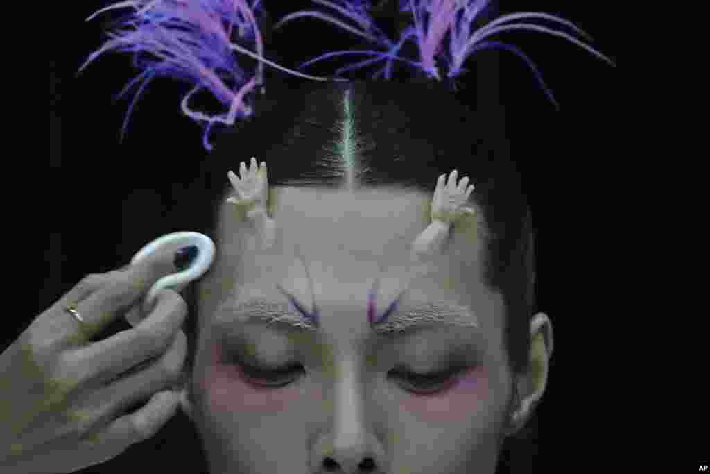 A model for the Dieyingchongchong collections by Chinese designer Dong Yaer has final makeup applied backstage during the China Fashion Week in Beijing, March 28, 2023.