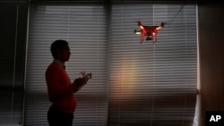 FILE - A staff member from DJI Technology Co. demonstrates the Phantom 2 Vision+ drone inside his office in Shenzhen, Guangdong province, China, Dec. 15, 2014.