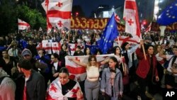 Demonstrators with Georgian national and EU flags rally during an opposition protest against a foreign influence bill as they mark their country's Independence Day, in the center of in Tbilisi, Georgia, May 26, 2024.