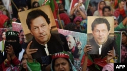Supporters of Pakistan's former prime minister Imran Khan carry placards displaying a portrait of Khan during a protest in Karachi, March 19, 2023, demanding the release of party workers arrested in recent police clashes.