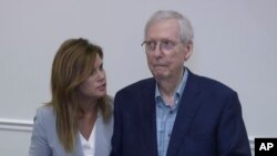 Robbin Taylor, an aide to U.S. Sen. Mitch McConnell, R-Ky., joins McConnell while he speaks at the Madison Event Center, Aug. 30, 2023, in Covington, Ky. McConnell appeared to briefly freeze up, weeks after he had a similar episode in Washington.