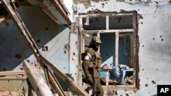 Seorang pejuang Taliban memeriksa rumah anggota ISIS yang hancur dalam konflik yang sedang berlangsung antara keduanya di Kabul, Afghanistan, Kamis, 5 Januari 2023. (AP/Ebrahim Noroozi)