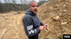 Licensed Virginia gold miner Paul Busch displays a rock tossed aside by previous prospectors that contains enough gold to process with modern technology and higher prices, at his Goochland County, Virginia, reclamation site. (Steve Herman/VOA)