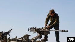 Seorang tentara Israel memeriksa senjata saat berada di wilayah Golan dekat perbatasan Suriah, pada 28 Desember 2023. (Foto: AFP/Jalaa Marey)