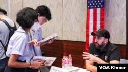 សិស្សានុសិស្សកំពុង​សន្ទនាជាមួយ​អ្នក​ណែនាំ​របស់​សាកល​វិទ្យាល័យ​ក្នុង​សហរដ្ឋ​អាមេរិក​ពី​កម្មវិធី​សិក្សា​ផ្សេងៗ​ ​ ក្នុង​កម្មវិធី​​ពិព័រណ៍​កម្មវិធី​សិក្សា ​EducationUSA ក្នុង​រាជធានី​ភ្នំពេញ កាល​ពីថ្ងៃទី​២៨ ខែ​កញ្ញា ឆ្នាំ២០២៣។ (ស៊ឹម ចាន់សំណាង/វីអូអេ)